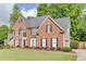 Two-story brick home with a well-manicured lawn and mature trees at 352 Hickory Haven Ter, Suwanee, GA 30024