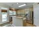 Bright kitchen with stainless steel appliances, light wood cabinets, and outdoor access at 352 Hickory Haven Ter, Suwanee, GA 30024