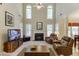 Bright living room featuring a fireplace, soaring ceilings, and plush leather armchairs at 352 Hickory Haven Ter, Suwanee, GA 30024