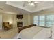 Comfortable main bedroom featuring a fireplace, trey ceiling, and a cozy seating area at 352 Hickory Haven Ter, Suwanee, GA 30024