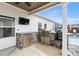 Covered outdoor kitchen features stone accents, stainless steel appliances, and a built in grill near the pool at 39 Summer Nw Pl, Cartersville, GA 30121