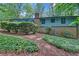 Back exterior with brick foundation, lush vegetation, and a deck at 4856 Rock Haven Dr, Lilburn, GA 30047