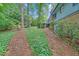 Well-maintained backyard featuring a brick chimney, green groundcover, and access to upper level deck at 4856 Rock Haven Dr, Lilburn, GA 30047