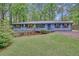 Charming single-story home featuring blue siding, a welcoming front porch, and a lush, wooded lot at 4856 Rock Haven Dr, Lilburn, GA 30047