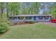 Charming single-story home featuring a covered porch, lush lawn, and colorful shrubbery at 4856 Rock Haven Dr, Lilburn, GA 30047