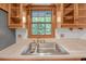 Kitchen featuring a stainless steel sink and faucet beneath a window with natural light and wood cabinets at 4856 Rock Haven Dr, Lilburn, GA 30047