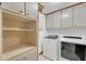 Bright laundry room with white cabinetry, storage shelves and modern washer and dryer units at 4856 Rock Haven Dr, Lilburn, GA 30047