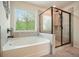 Spacious bathroom with soaking tub, stand up shower, and a large window bringing in natural light at 6915 Rambling Vale, Cumming, GA 30028
