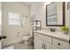 Bathroom featuring a granite countertop, a framed mirror, and white cabinetry, offering a clean and functional space at 6915 Rambling Vale, Cumming, GA 30028