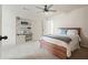 Simple bedroom includes a wooden bed frame, a storage cabinet, and a ceiling fan, offering a tranquil space at 6915 Rambling Vale, Cumming, GA 30028