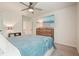 Inviting bedroom with a ceiling fan, light-colored carpet, and a large television for entertainment at 6915 Rambling Vale, Cumming, GA 30028