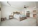 Large bedroom features a wooden bed frame with a gray striped comforter, tray ceilings, and soft carpeted floors at 6915 Rambling Vale, Cumming, GA 30028