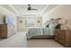 Spacious bedroom featuring a tray ceiling, fan, and neutral color palette at 6915 Rambling Vale, Cumming, GA 30028