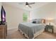 Cozy bedroom with a ceiling fan, comfortable bedding, and natural light from the window with blinds at 6915 Rambling Vale, Cumming, GA 30028