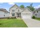 Charming two-story home with a two-car garage, manicured lawn, and stone accents at 6915 Rambling Vale, Cumming, GA 30028