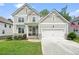 Charming two-story home with a two-car garage, manicured lawn, and stone accents at 6915 Rambling Vale, Cumming, GA 30028
