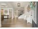 Open foyer with hardwood floors, a staircase, decorative bench, and elegant light fixture at 6915 Rambling Vale, Cumming, GA 30028