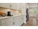Modern kitchen featuring white cabinetry, quartz countertops, stainless steel appliances, and hardwood floors at 6915 Rambling Vale, Cumming, GA 30028