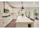 Bright kitchen with a central island, stainless steel appliances, and a seamless connection to the outdoor patio at 6915 Rambling Vale, Cumming, GA 30028