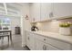 Bright kitchen featuring white cabinets, quartz countertops, subway tile backsplash, and stylish decor, creating a modern culinary space at 6915 Rambling Vale, Cumming, GA 30028