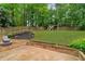 Fenced backyard boasts a playground, fire pit area, and lush lawn perfect for outdoor activities at 2640 Garland Way, Duluth, GA 30096