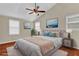 Staged bedroom featuring a ceiling fan, wood floors, neutral walls, and beach themed decor at 2640 Garland Way, Duluth, GA 30096
