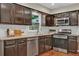 Well-lit kitchen featuring dark cabinets, stainless steel appliances, granite countertops, and white subway tile backsplash at 2640 Garland Way, Duluth, GA 30096