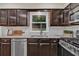 Well-lit kitchen featuring dark cabinets, stainless steel appliances, granite countertops, and white subway tile backsplash at 2640 Garland Way, Duluth, GA 30096