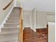 Carpeted staircase with wooden handrail leading to the upper level, with hardwood floors in the adjacent room at 2640 Garland Way, Duluth, GA 30096