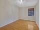 Bedroom with hardwood floors, natural light from a window, and a ceiling light fixture at 6027 Wintergreen Rd, Norcross, GA 30093