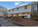 A well-maintained two-story townhouse complex features neutral siding, large windows, and mature landscaping for curb appeal at 6027 Wintergreen Rd, Norcross, GA 30093