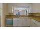 Bright kitchen featuring granite counters, white cabinets, stainless steel sink and open view to dining area at 6027 Wintergreen Rd, Norcross, GA 30093