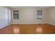 Expansive main bedroom with gleaming hardwood floors, two windows, and a double door closet at 6027 Wintergreen Rd, Norcross, GA 30093