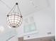 A modern interior featuring a striking globe chandelier hanging over a glass railed staircase at 845 Spring Nw St # 408, Atlanta, GA 30308