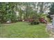 A backyard with a small storage shed and a red deck with stairs overlooking the trees at 1934 Mcconnell Rd, Grayson, GA 30017