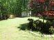 A backyard with a storage shed, a wooden fence, trees, and shrubbery at 1934 Mcconnell Rd, Grayson, GA 30017