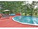 Relaxing pool area with deck, chairs, and a view of the surrounding lush greenery and tall trees at 1934 Mcconnell Rd, Grayson, GA 30017