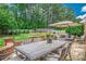 This backyard has a stone patio with dining table, umbrella, and comfortable seating at 9810 Foxworth Dr, Alpharetta, GA 30022