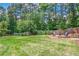 The expansive backyard features lush green grass, a fire pit with chairs, and mature trees at 9810 Foxworth Dr, Alpharetta, GA 30022