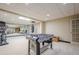 Spacious basement area with gym equipment, mirrored wall, and foosball table for recreation and fitness at 9810 Foxworth Dr, Alpharetta, GA 30022