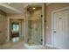 Luxurious walk-in shower with neutral tile, glass door, and easy access to the bedroom at 9810 Foxworth Dr, Alpharetta, GA 30022