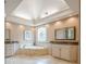 Primary bathroom featuring a large soaking tub with tile surround, plus dual sinks at 9810 Foxworth Dr, Alpharetta, GA 30022