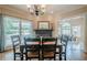 Bright dining room area featuring a dark fireplace, large windows, and a view into the living room at 9810 Foxworth Dr, Alpharetta, GA 30022