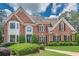 Elegant two-story brick home featuring manicured landscaping and a classic architectural design at 9810 Foxworth Dr, Alpharetta, GA 30022