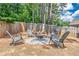 The backyard has a fire pit with four gray chairs and landscaping rocks at 9810 Foxworth Dr, Alpharetta, GA 30022