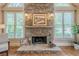 Close-up on a floor to ceiling stone fireplace flanked by windows at 9810 Foxworth Dr, Alpharetta, GA 30022