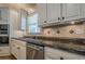 Kitchen with stainless steel dishwasher, granite countertops, tile backsplash, and white cabinetry at 9810 Foxworth Dr, Alpharetta, GA 30022