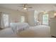 Spacious primary bedroom featuring neutral color palette, two ceiling fans, a desk area, and bright natural light at 9810 Foxworth Dr, Alpharetta, GA 30022