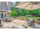 This home has a stone patio with an umbrella, a dining table, and seating at 9810 Foxworth Dr, Alpharetta, GA 30022
