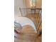 Close-up of a winding staircase with hardwood treads and decorative iron railing at 9810 Foxworth Dr, Alpharetta, GA 30022